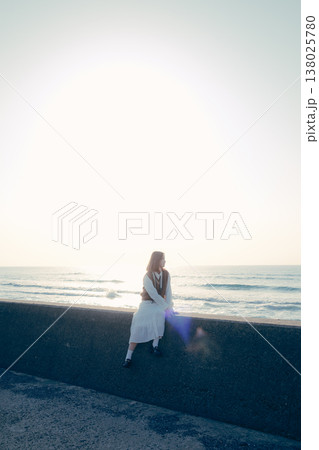 海辺でカメラを持つ若い女性のポートレート 138025780