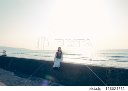 海辺でカメラを持つ若い女性のポートレート 138025781