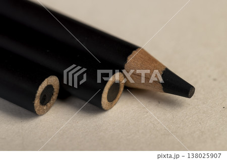 a row of black wooden pencils folded on cheap loose paper, wooden pencils with lead for drawing or other work a row of black wooden pencils folded on cheap loose paper, wooden pencils with lead for drawing or other work 138025907