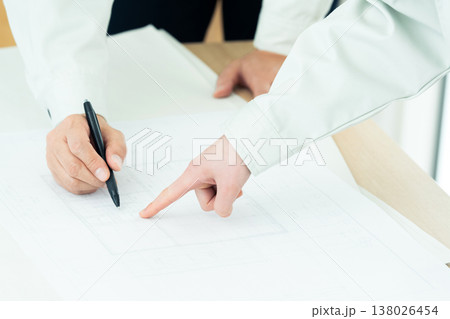 図面を見る作業着姿の男女の手元 図面を見る作業着姿の男女の手元 138026454