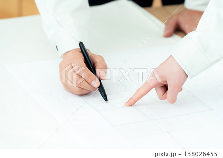 図面を見る作業着姿の男女の手元 図面を見る作業着姿の男女の手元 138026455