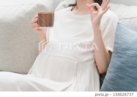 ソファーで飲み物を飲む妊婦　ライフスタイルイメージ 138026737