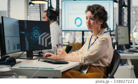Office administrator checking monthly reports with AI analytics platform, employing neural networks algorithms and automation for efficiency. IT company representative at work. Camera B. 138027221