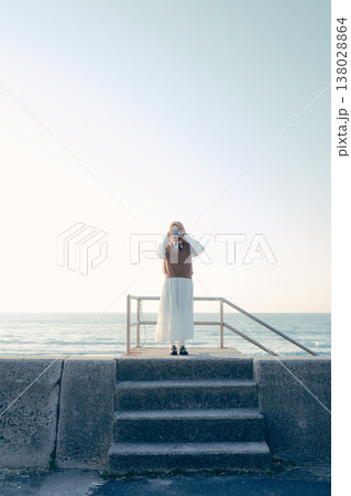 海辺でカメラを構える若い女性 海辺でカメラを構える若い女性 138028864
