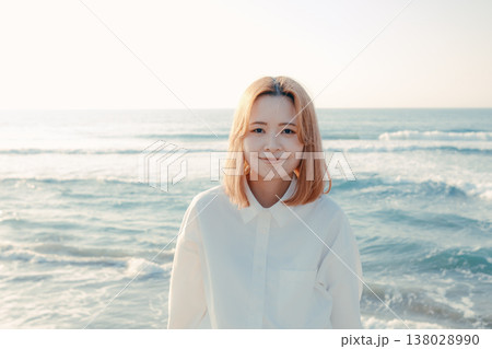 海辺で目を閉じる女性 138028990