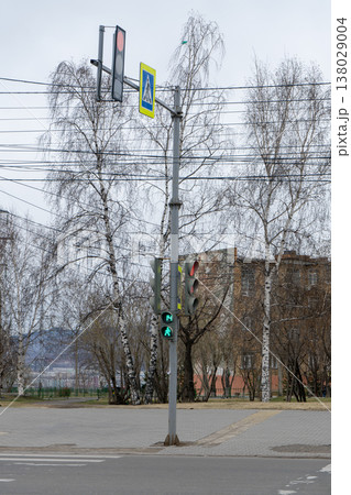 A traffic light on a pole on a sidewalk in the city. A traffic light on a pole on a sidewalk in the city. 138029004