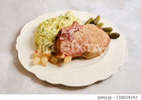 Pork rib chop served with mashed potatoes and pickles during dinner time Pork rib chop served with mashed potatoes and pickles during dinner time 138029242