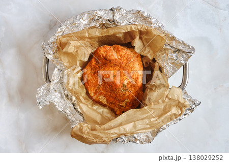 Cooking pork shoulder wrapped in foil with brown paper for flavor enhancement in the kitchen Cooking pork shoulder wrapped in foil with brown paper for flavor enhancement in the kitchen 138029252