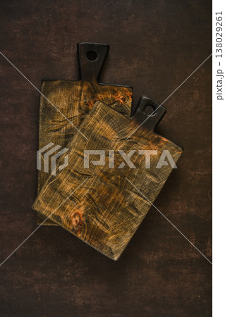 Cutting boards placed on a dark surface for food preparation in a kitchen setting 138029261