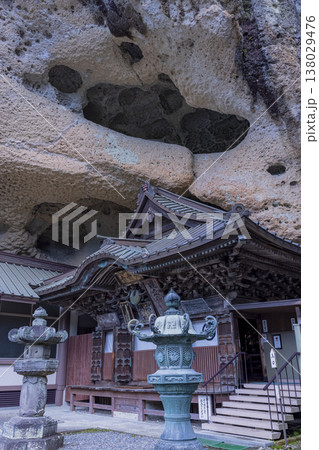 岩窟に建つ古刹の本堂と石灯籠 138029476