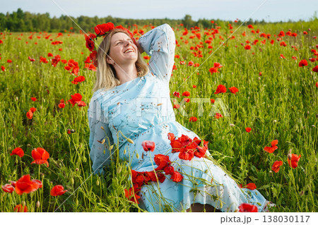 A girl in a blue dress, standing still where the poppies blaze. A quiet moment in a sea of red wild beauty meets gentle calm. A girl in a blue dress, standing still where the poppies blaze. A quiet moment in a sea of red wild beauty meets gentle calm. 138030117