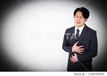 腹痛に苦しむスーツ姿のミドル男性ビジネスマン 腹痛に苦しむスーツ姿のミドル男性ビジネスマン 138030630