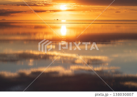 Peaceful orange sunset sky reflection on Salar de Uyuni Bolivia 138030807