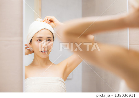 洗面所でヘアケアをする女性 洗面所でヘアケアをする女性 138030911