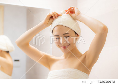 洗面所でヘアケアをする女性 洗面所でヘアケアをする女性 138030918