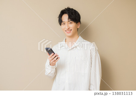 スマホを見る若い男性　 138031113