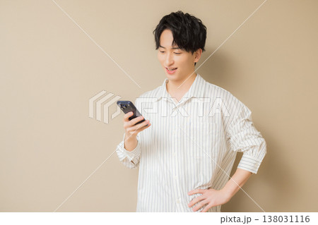 スマホを見る若い男性　 138031116