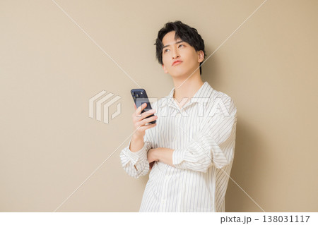 スマホを見る若い男性 138031117