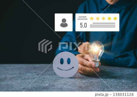 Business employee shows high customer satisfaction rating near happy face icon, person holds glowing lightbulb for happy client service feedback and five star user experience Business employee shows high customer satisfaction rating near happy face icon, person holds glowing lightbulb for happy client service feedback and five star user experience 138031128