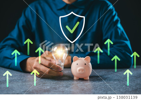 Innovation for financial business ideas shows hand holding glowing lightbulb near piggy bank, representing creative financial innovation concept for wealth growth and research 138031139