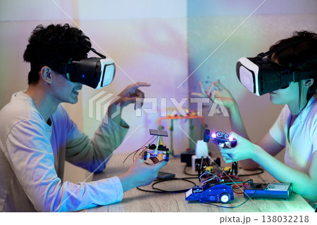Young man and young woman amateur inventor testing electronic device model 138032218