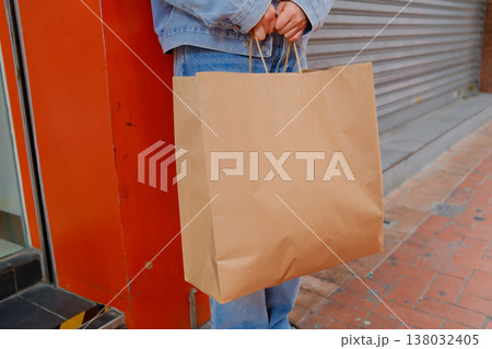 Woman holding kraft paper shopping bag standing on Hong Kong street steps urban casual lifestyle Woman holding kraft paper shopping bag standing on Hong Kong street steps urban casual lifestyle 138032405