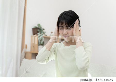 頭が痛い若い女性　頭痛　偏頭痛　片頭痛 138033025