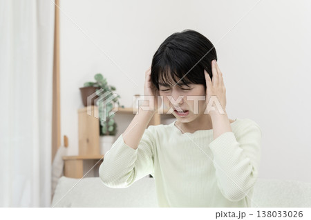 頭が痛い若い女性　頭痛　偏頭痛　片頭痛 138033026