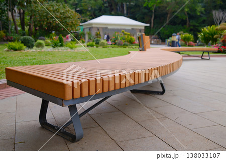 Modern wooden bench on stone base in Hong Kong park seating area 138033107