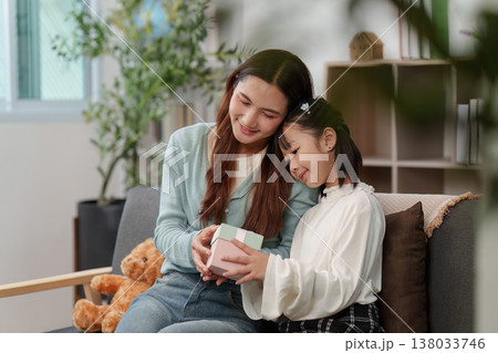Mother and daughter exchanging a gift with affection Mother and daughter exchanging a gift with affection 138033746