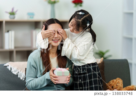 Daughter surprising mother with a gift at home Daughter surprising mother with a gift at home 138033748