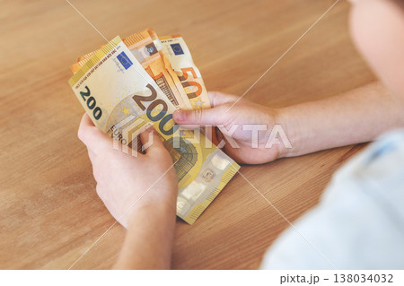 Close up hands holding euro banknotes, counting European cash money in natural light. Financial concept of income, savings, payment and budget management, economy and personal finance Close up hands holding euro banknotes, counting European cash money in natural light. Financial concept of income, savings, payment and budget management, economy and personal finance 138034032