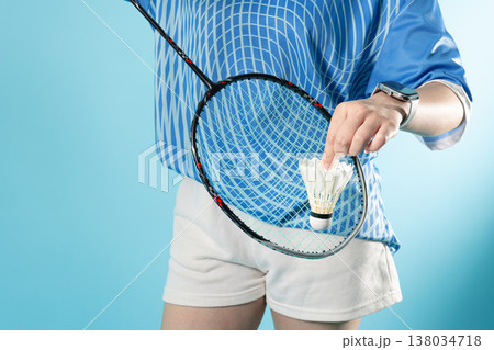 Closeup Badminton player holding badminton racket serve shuttlecock action with copy space 138034718