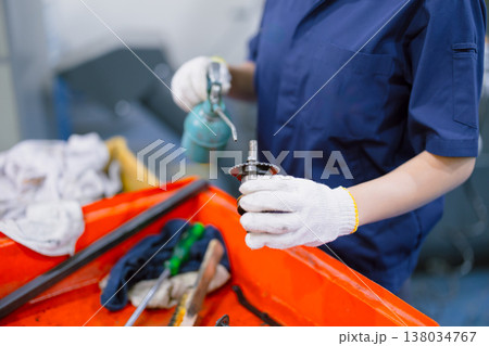 worker hand holding long neck oil lubricant lube oil drop at machine part in heavy industry workshop worker hand holding long neck oil lubricant lube oil drop at machine part in heavy industry workshop 138034767
