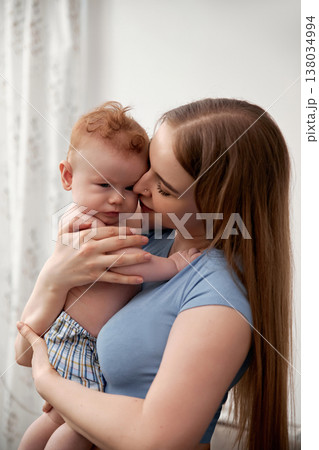 Cherished moments between mother and baby showcasing love and tenderness in a cozy indoor setting emphasizing family bonding concept 138034994