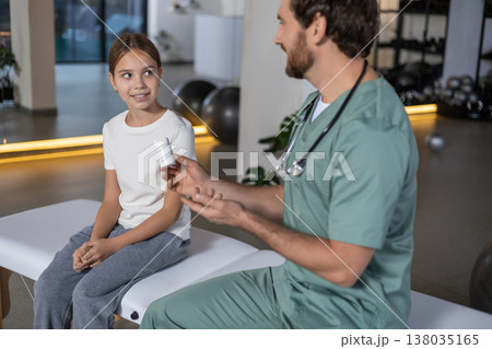 Doctor gesturing and talking about pills to young girl Doctor gesturing and talking about pills to young girl 138035165