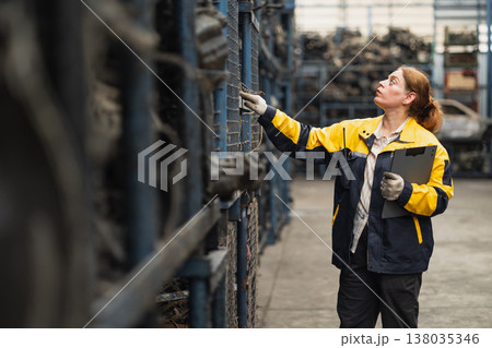 Technician adult women worker working in heavy industry, warehouse manager in garage scrap yard Technician adult women worker working in heavy industry, warehouse manager in garage scrap yard 138035346