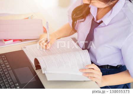 Student doing homework, Asian Thai uniform women education learning working reading a book writing 138035373