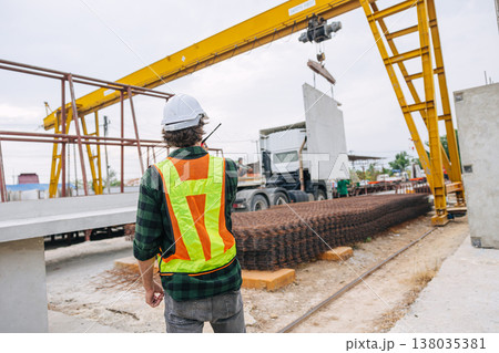 Professional engineer male working in concrete precast plant factory control operate lifting crane in construction site . Professional engineer male working in concrete precast plant factory control operate lifting crane in construction site . 138035381