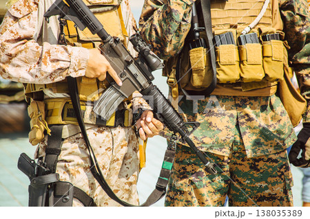 Modern soldiers dressed in camouflage. Military army with tactical weapon closeup 138035389