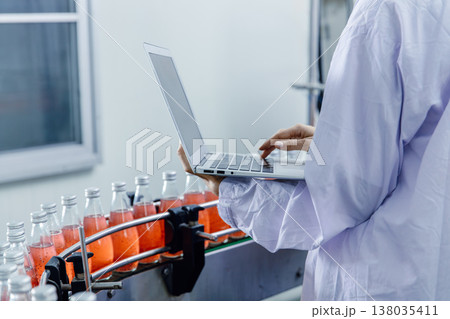 Closeup worker using laptop record products data at production line in food and drinks factory 138035411