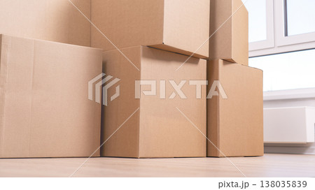 Stacked brown boxes sit neatly on wooden floor Stacked brown boxes sit neatly on wooden floor 138035839