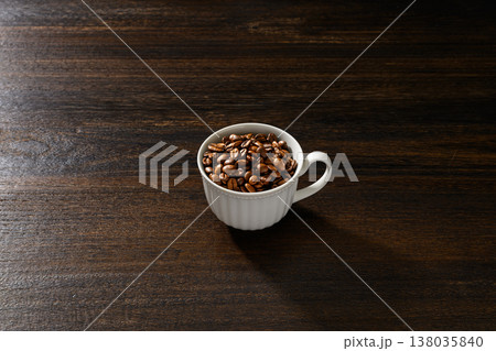 白いカップに入ったコーヒー豆と木目背景 138035840