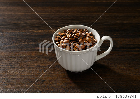白いカップに入ったコーヒー豆と木目背景 白いカップに入ったコーヒー豆と木目背景 138035841