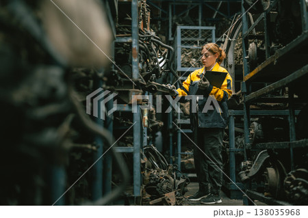 Technician adult women worker working in heavy industry, warehouse manager in garage scrap yard Technician adult women worker working in heavy industry, warehouse manager in garage scrap yard 138035968