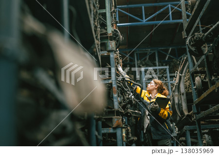 Technician adult women worker working in heavy industry, warehouse manager in garage scrap yard Technician adult women worker working in heavy industry, warehouse manager in garage scrap yard 138035969