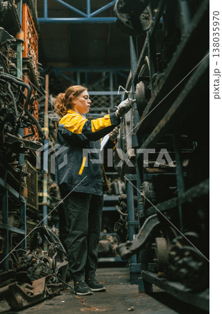 Technician adult women worker working in heavy industry, warehouse manager in garage scrap yard Technician adult women worker working in heavy industry, warehouse manager in garage scrap yard 138035970