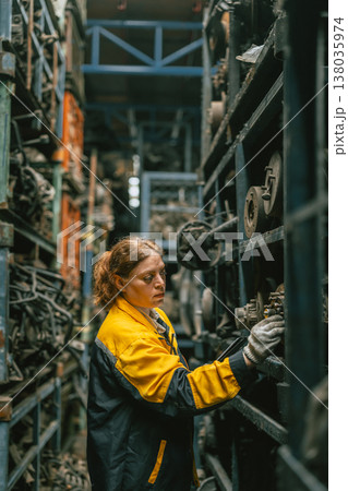 Technician adult women worker working in heavy industry, warehouse manager in garage scrap yard Technician adult women worker working in heavy industry, warehouse manager in garage scrap yard 138035974