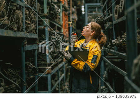 Technician adult women worker working in heavy industry, warehouse manager in garage scrap yard 138035978
