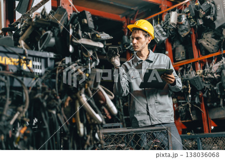 Technician male worker working in garage scrap yard old car part workshop warehouse 138036068